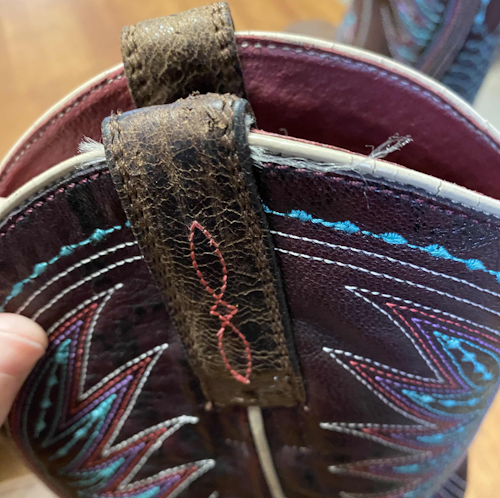 A close-up of the bootstraps, showing the dried damaged leather and frayed threads.