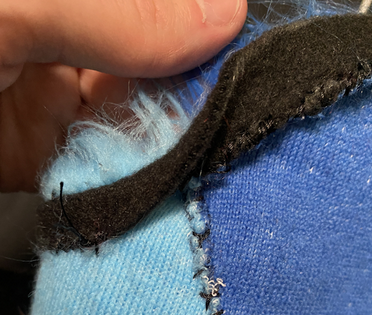 Sewing down the cuffs of the arm sleeves.