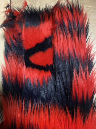 Photo of the fluffy red and black wrists of the arm, one part has been shaved revealing round red markings.
